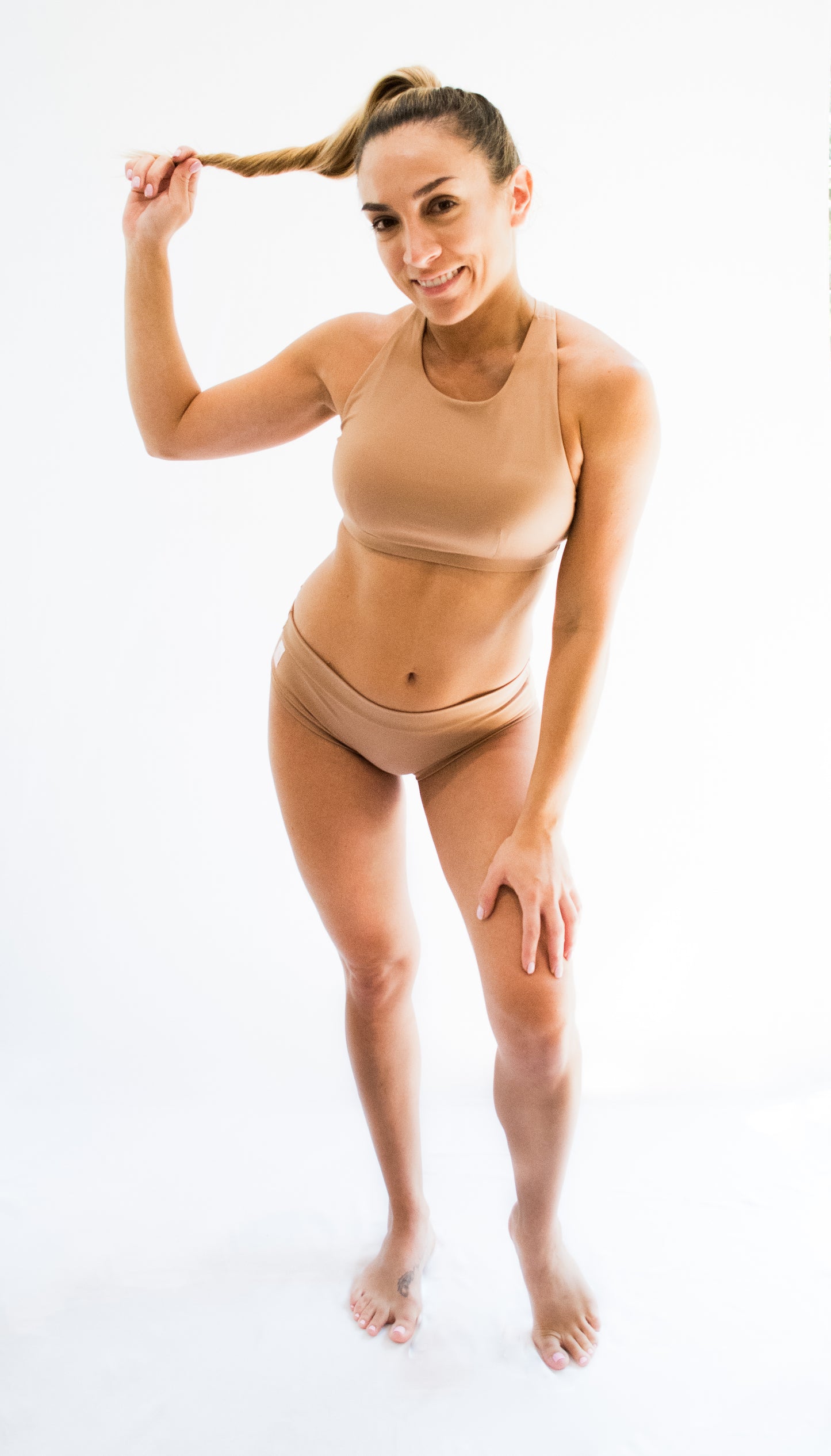 Model wearing a nude colored pole dancing outfit