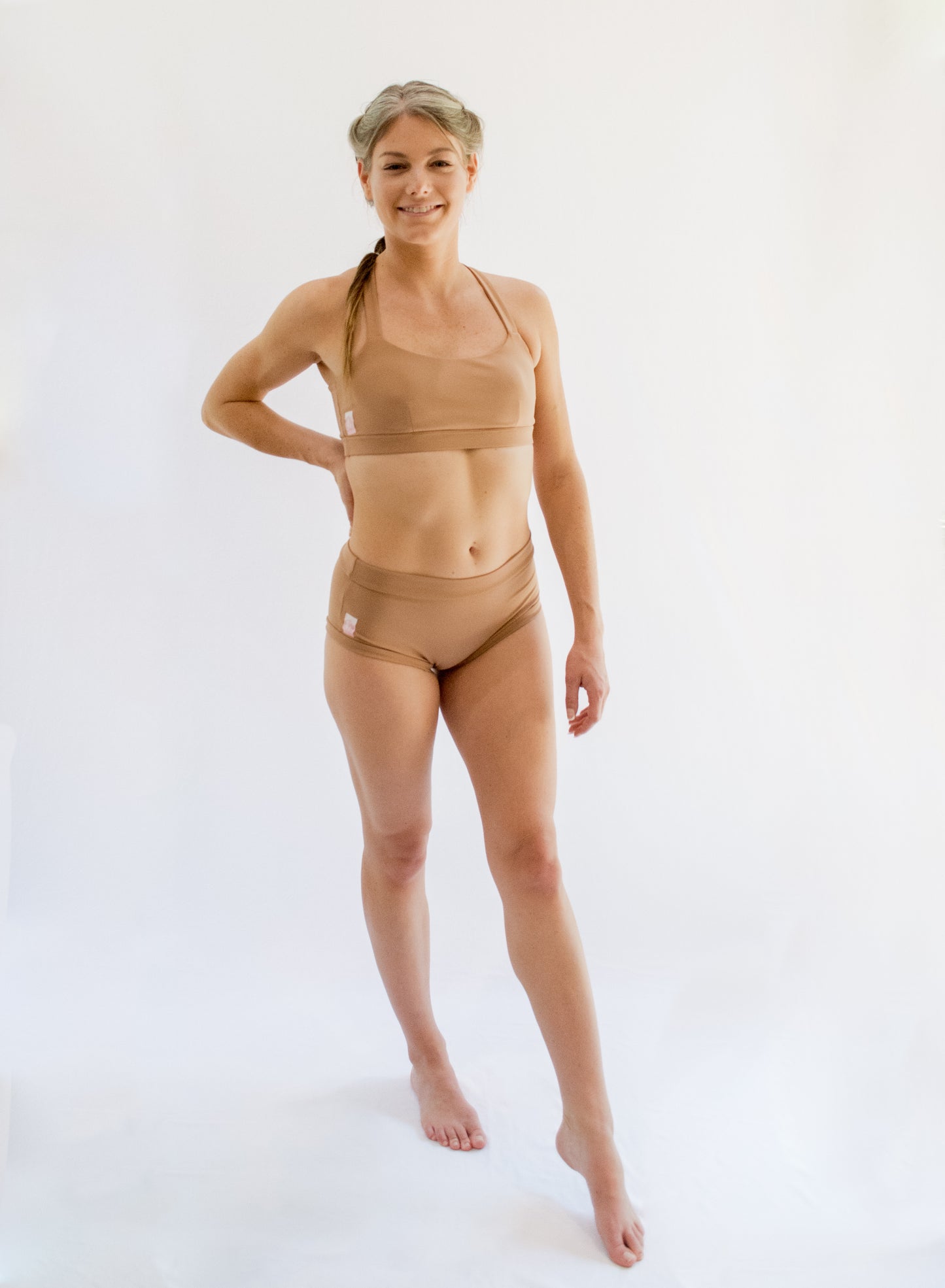 Model wearing a nude colored pole dancing set. Matching pole sports bra and pole bottom. 
